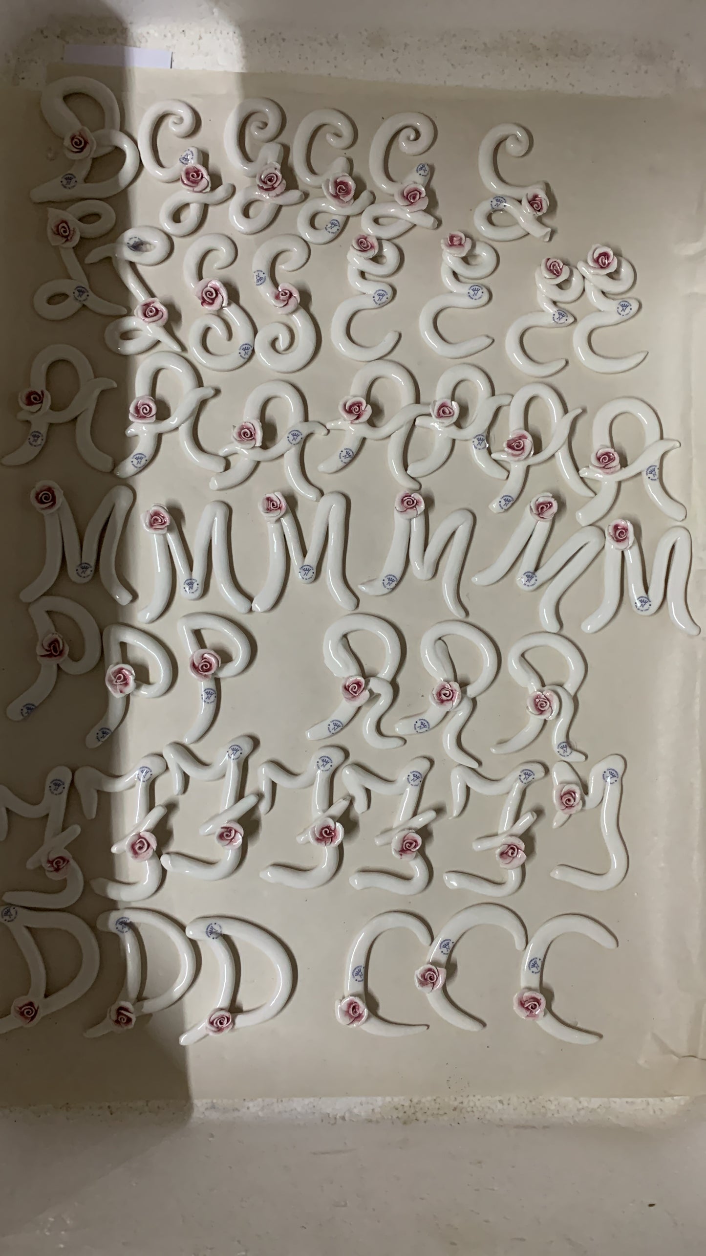 Iniziale ceramica con rosa e nastro in seta come segnaposto